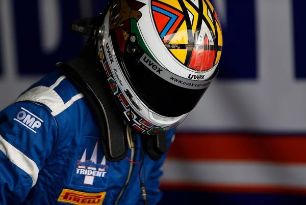 Axcil Jefferies climbing into his Trident Motorsport GP2 car in Bahrain featuring his Kustomflow painted helmet